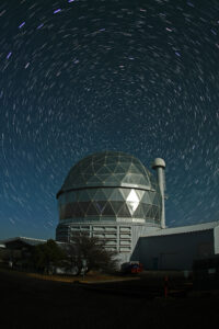 Large telescope under a starry night sky.